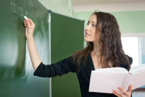 Image d'une professeure écrivant au tableau. Professeurs particuliers. Soutien scolaire Vend'études.